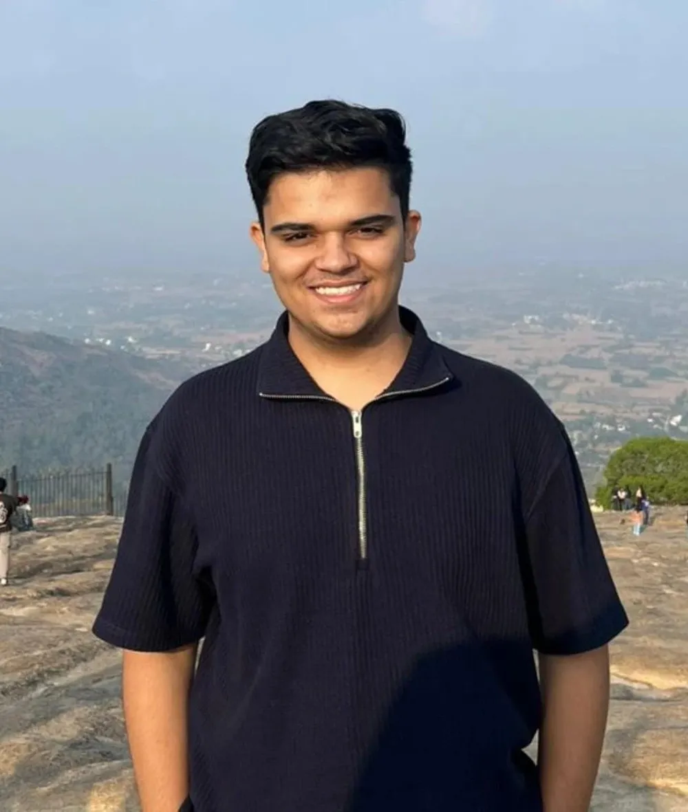 Shubh Desai, smiling, on a hilltop